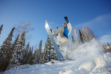 Snowboarder jumping from the springboard against the sky