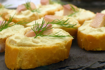 Canapes. Baguette slices with fish spread and fish.