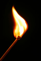 burning matchstick on black background