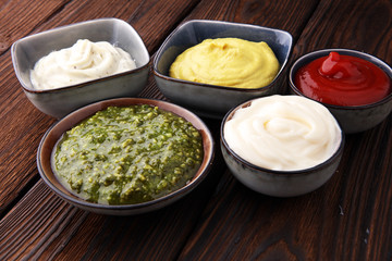 Set of sauces - ketchup, mayonnaise, mustard bbq sauce, pesto, mustard on wooden table