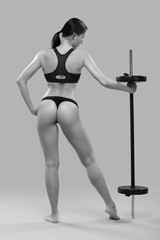 Fototapeta na wymiar slender girl in a black bikini posing with a barbell