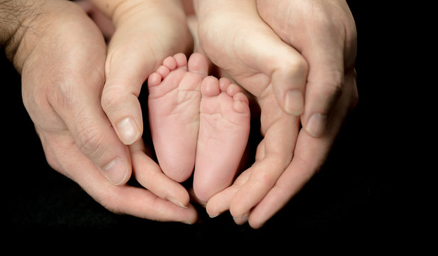 Newborn Baby feet in parents' hands -  happy family moments of parents with their children