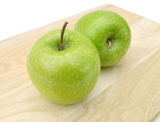 Ripe green apple with slices isolated on wooden board