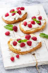 Breakfast slice of bread with Ricotta cheese served with raspberries