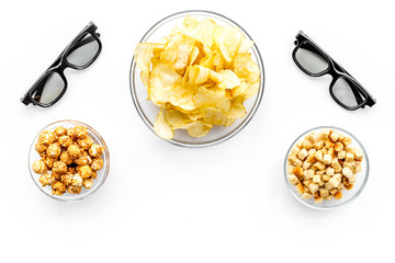 Fast food for watching film. Crisps, popcorn, rusks near glasses on white background top view copyspace