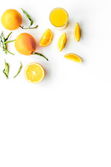 Orange juice in glass near slices of oranges on white background top view copyspace