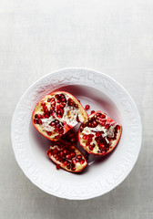 pomegranate with red seeds in a bowl on the kitchen table