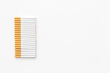 Fototapeta na wymiar Tobacco. Row of cigarettes on white background top view copyspace