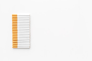 Tobacco. Row of cigarettes on white background top view copyspace