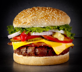 Big burger with lettuce, onion, tomato, cheese and pickles
