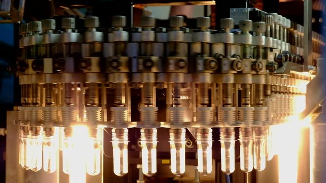 PET bottle preforms. The operation of PET bottle or plastic bottle blowing machine with lighting effect.