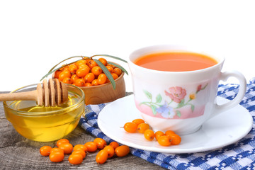 Sea buckthorn in wooden bowl, honey, Sea buckthorn juice on wooden table.