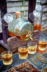 Alcohol,taste and drink concept-glasses with whiskey,old glass barrel on stone table and wooden background.