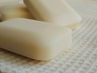 Bars of natural soap on white natural linen waffle texture towel.