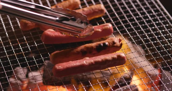 Sausages grilling over the flames