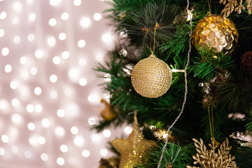 Christmas tree with toys, lights, garland, bokeh on background