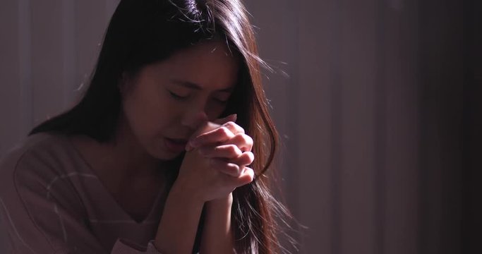 Woman pray for god in the dark