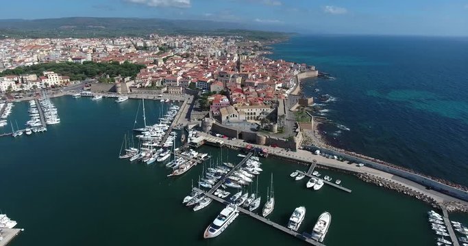 ALGHERO, SARDINIA, ITALY  &ndash; JULY 2016 : Aerial shot over Alghero cityscape on a beautiful day with harbor and open sea in view