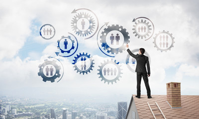 Businessman on house roof presenting teamwork and connection concept. Mixed media