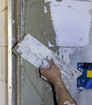 worker plastering tool plaster marble on interior plaster rough.  Selective focus