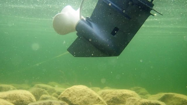 Trim tilt motor tilting an outboard motor. Underwater shot.