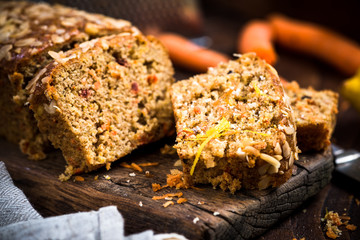 Carrot cake sliced on wooden rustic board.