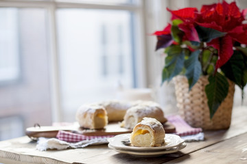 Christmas baked goods on a table near a window and a flower with red leaves