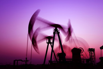 Is operation of pumping unit under the sunset of oilfield, close-up