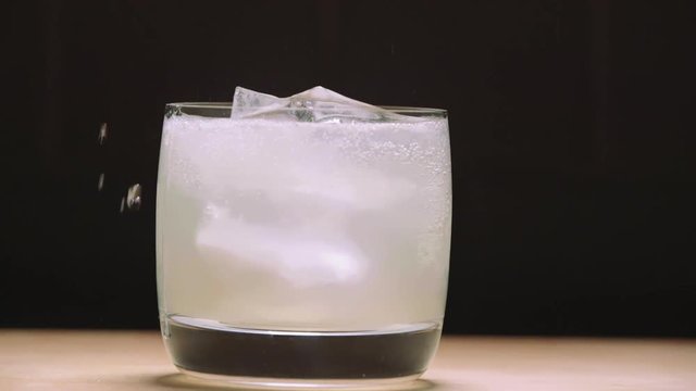 pouring seltzer water into a mojito