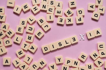 Dyslexia concept - alphabet tiles on a pink background