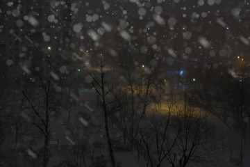 Night snowy town with buildings and street light. Winter city background