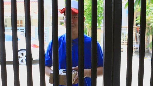 delivery man delivering container box to woman home