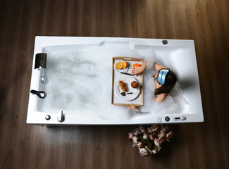 Luxury fashion woman in the morning take breakfast in hotel spa lying in bath tub
