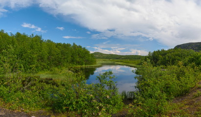 Lake of the woods ,the hills , the clouds in the sky.