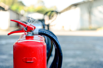 closeup red fire extinguisher with soft-focus and over light in the background