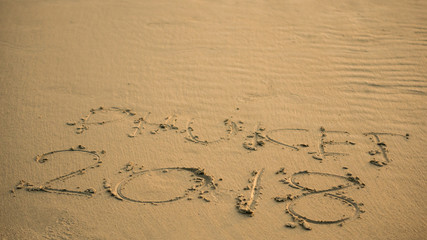 The letters on the sandy beach, the numeric 2018 to welcome the new year