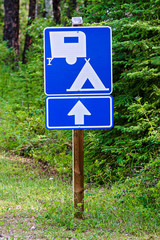 A blue information sign indicating camping ahead