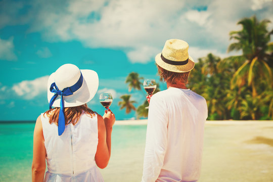 happy loving couple celebration drinking wine at beach