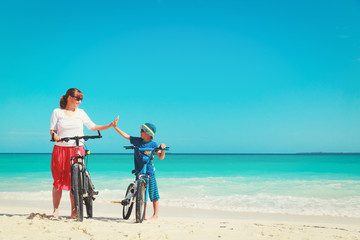 Obraz na płótnie Canvas Happy mother and son biking at beach