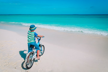 Fototapeta na wymiar little boy riding bike on tropical beach