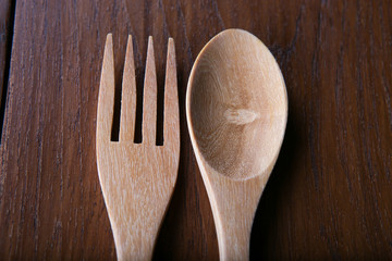 Wooden spoon and fork on wood texture of dining table from top view