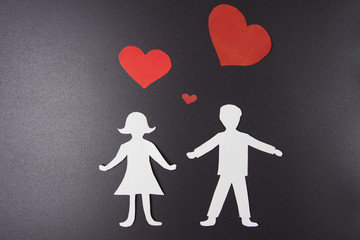 Love concept. Paper red hearts over man and woman in love on black background. St. Valentine's Day. Lovers of each other.
