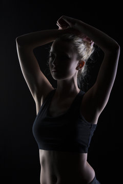 Beautiful fit and motivated blond woman portrait in black top giving a fist pump
