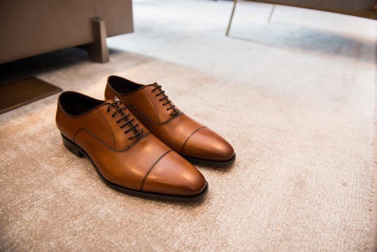 Brown leather classic male shoes on the floor in interior