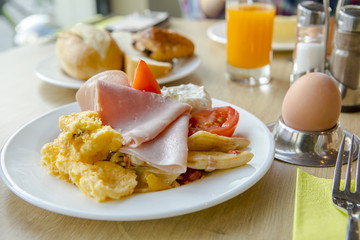 Fototapeta premium Bright and healthy breakfast, raw vegetables salad, fresh lettuce, cheese shakes, Western fried egg with the original bread,