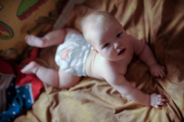American flag. Portrait of baby boy in colour sunny bedroom. Newborn child learning crawling. Nursery for children. Textile and bedding for kids. Happy caucasian child looking in a camera
