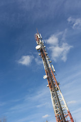 Red white transmitter with blue sky in background.