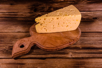 Cutting board with piece of cheese on a wooden table