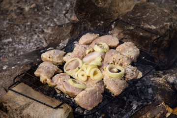 Spiced raw pork meat on grill outdoor. Preparation of shish kebab. Marinated meat on charcoal