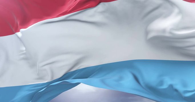 Luxembourg flag waving at wind with blue sky in slow, loop